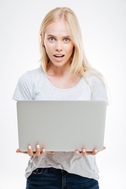 Beautiful excited woman holding laptop isolated on a white background