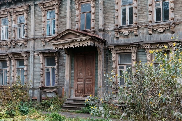 Фотография красивый фасад старых деревянных домов с резными оконными рамами и крыльцом