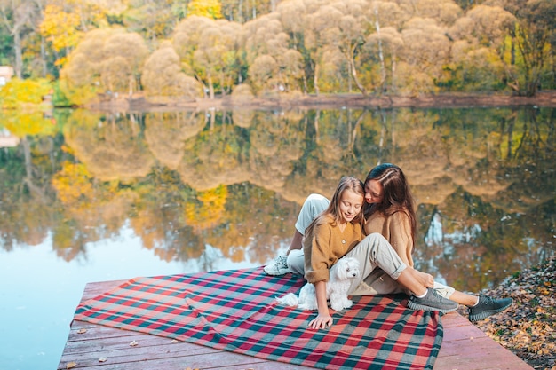 Beautiful family at autumn warm day near lake