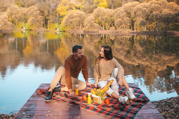 Beautiful family at autumn warm day near lake