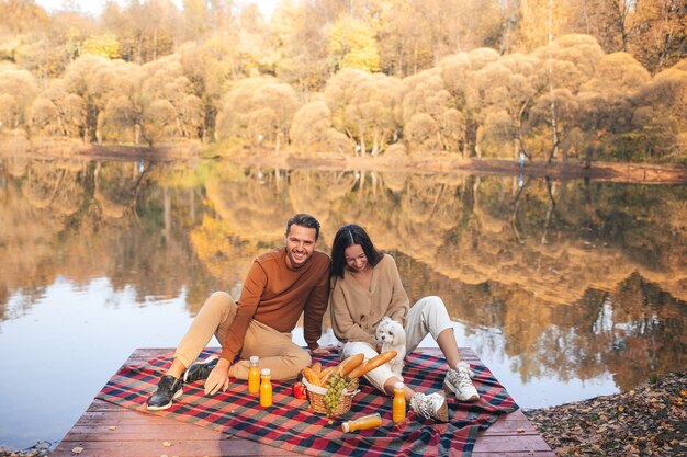 Beautiful family at autumn warm day near lake