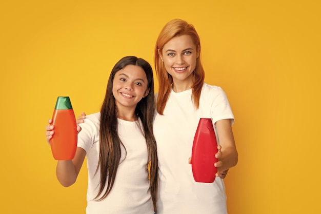 Beautiful family doing morning hair care Smiling mom kid in show clean mockup shampoo conditioner