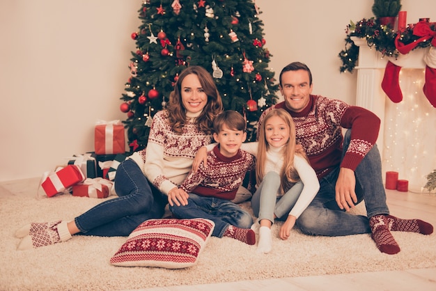 Beautiful family in knitted traditional Christmas costumes