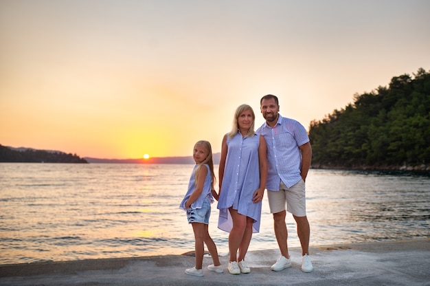 Beautiful family On the pier by the sea during sunset