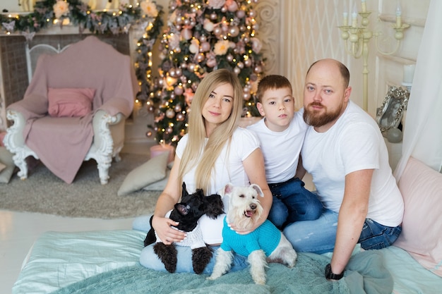 Beautiful family sitting near the Christmas tree