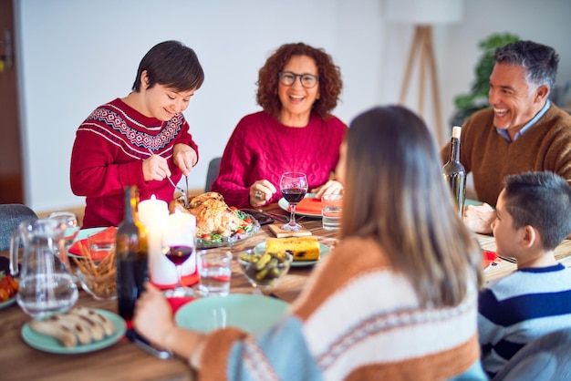 Beautiful family smiling happy and confident One of them curving roasted turkey celebrating christmas at home