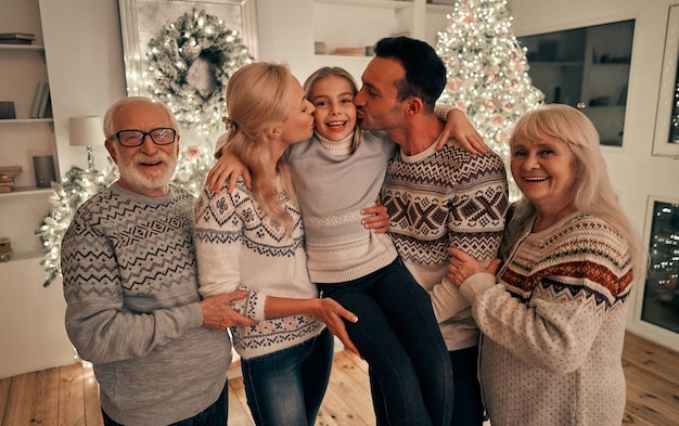 The beautiful family standing near the christmas tree