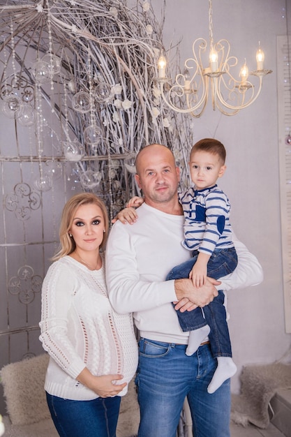 A beautiful family of three in anticipation of the baby dad mom\
and son in the new years interior