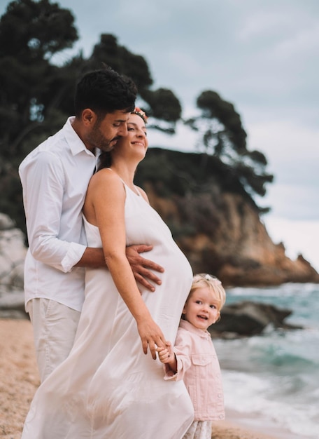 Bella famiglia che cammina lungo una spiaggia mediterranea