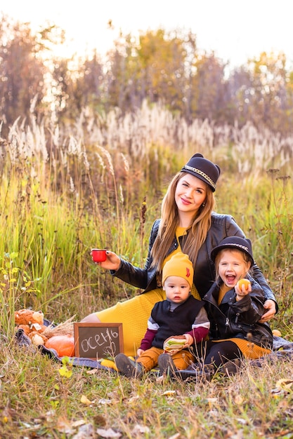 Beautiful family with a golden retriever dog on a walk in autumn sunny nature