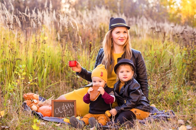 Beautiful family with a golden retriever dog on a walk in autumn sunny nature