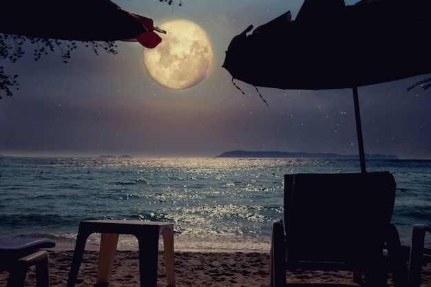 Foto bella spiaggia fantasia tropicale con la via lattea stella nel cielo notturno, luna piena - retro arte di stile con tonalità di colore vintage (elementi di questa immagine della luna fornito dalla nasa)