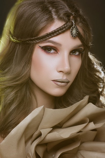 Beautiful fashion model girl with golden makeup.