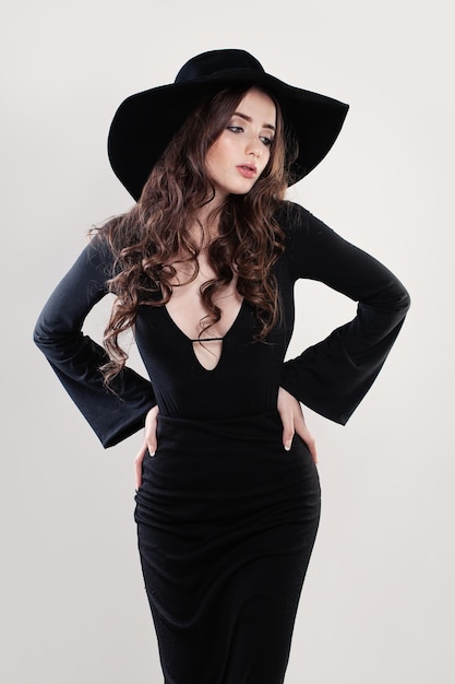 Beautiful Fashion Model Woman in a Black Hat. Young Beauty