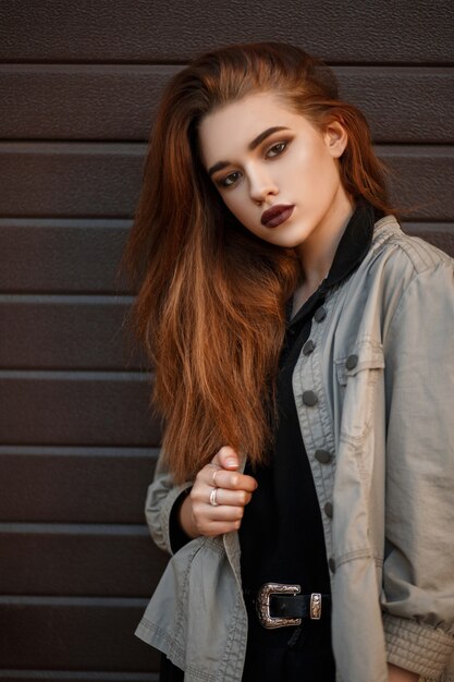 Beautiful fashion model woman in a stylish jacket and black polo on the street