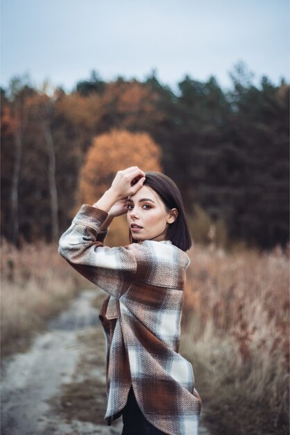 Beautiful fashion woman posing in autumn nature