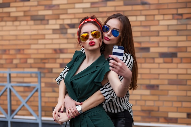 Beautiful fashion women posing on city background.