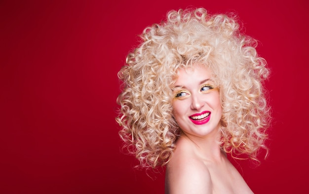 Beautiful fashionable blonde girl in retro style with voluminous curly hairstyle