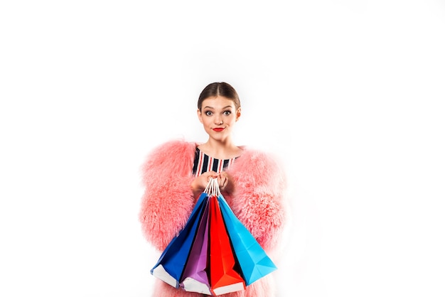 Beautiful fashionable and emotional lady in a swimsuit and a pink fluffy fur coat at a party.