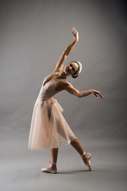 Beautiful female ballet dancer in beige suit