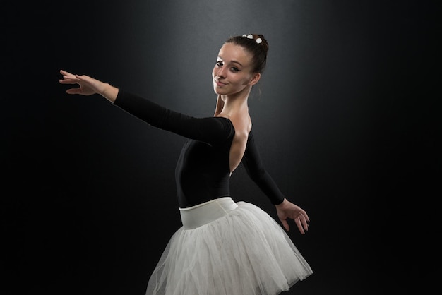 Beautiful Female Ballet Dancer On A Black Background  Ballerina Is Wearing A Tutu And Pointe Shoes