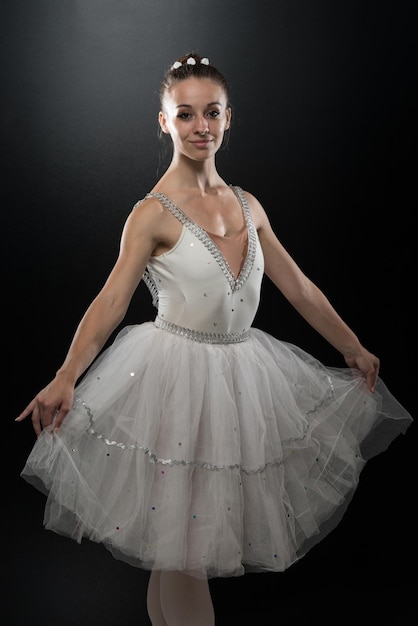 Beautiful Female Ballet Dancer On A Black Background  Ballerina Is Wearing A Tutu And Pointe Shoes