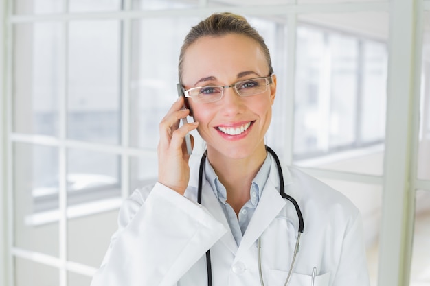 휴대 전화를 사용 하여 아름 다운 여성 의사