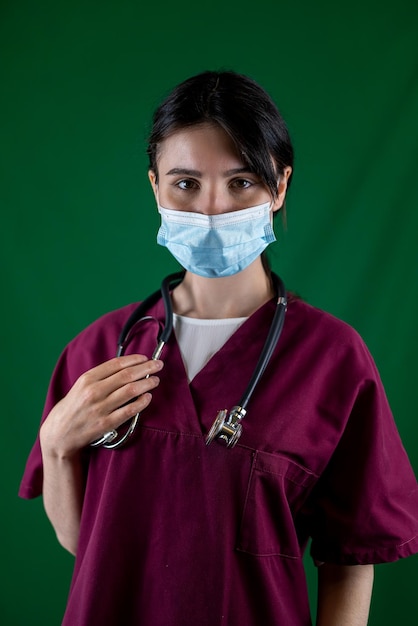 Beautiful female doctor in white coat with stethoscope waist up