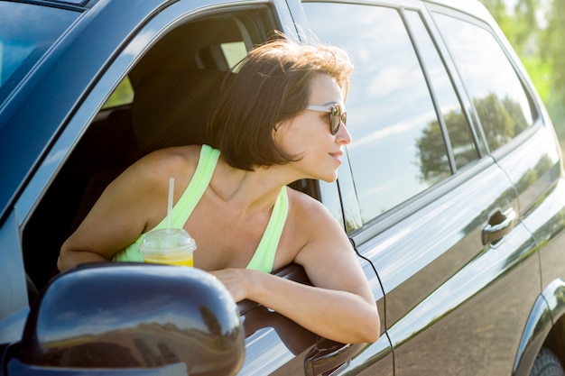 Foto bello autista femminile che sorride mentre guidando la sua automobile