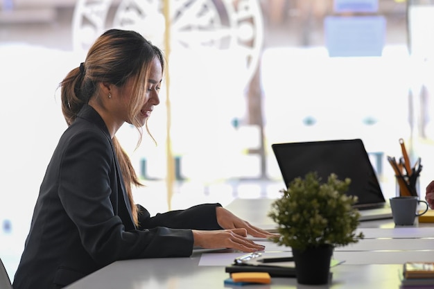 Beautiful female economist working with accounting documents at modern office