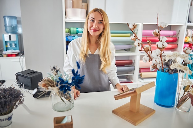 Beautiful female florist posing at her flower studio