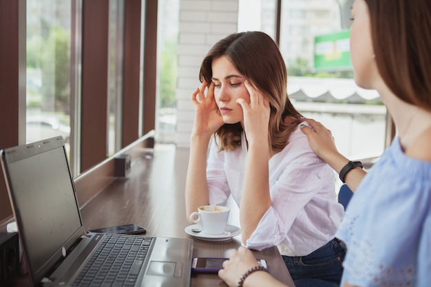 Belle amiche che godono insieme del caffè di mattina al caffè