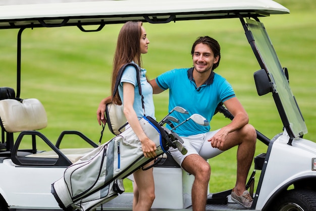 Bello giocatore di golf femminile che trasporta un sacchetto di golf