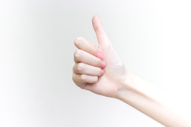 Beautiful female hand shows heart symbol as thumb up sign in manicure concept.