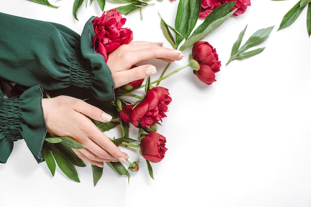 Beautiful female hand with red flowers on white 