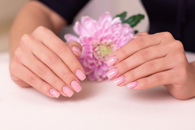 Beautiful female hands with wedding manicure nails pink gel polish peony flower