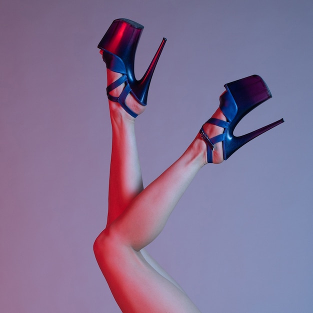 Photo beautiful female legs in blue high-heeled shoes