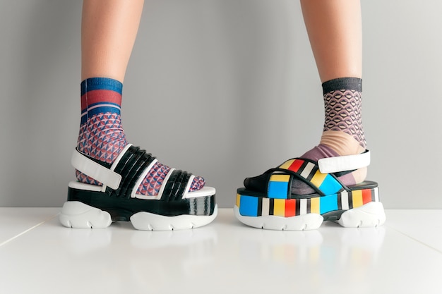 Beautiful female legs in colorful mismatched socks and sandals