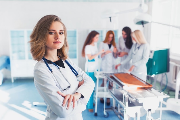 Beautiful female medical student on the background of the group in the operating room