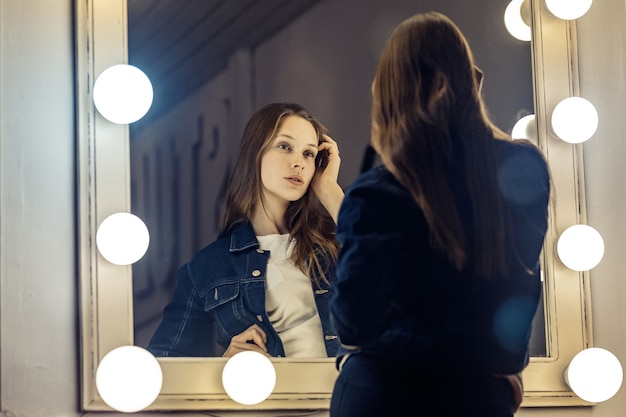 Beautiful female model posing near mirror