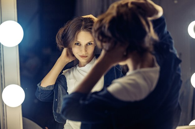 Beautiful female model posing near mirror