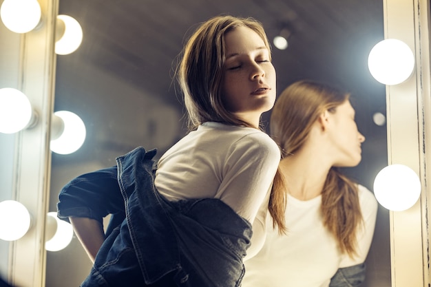 Beautiful female model posing near mirror