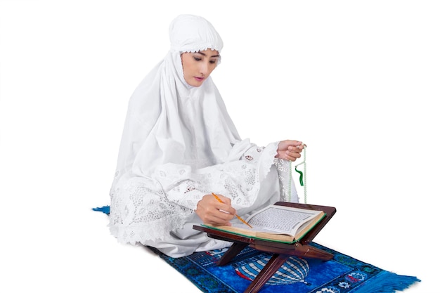 Photo beautiful female muslim read kuran isolated