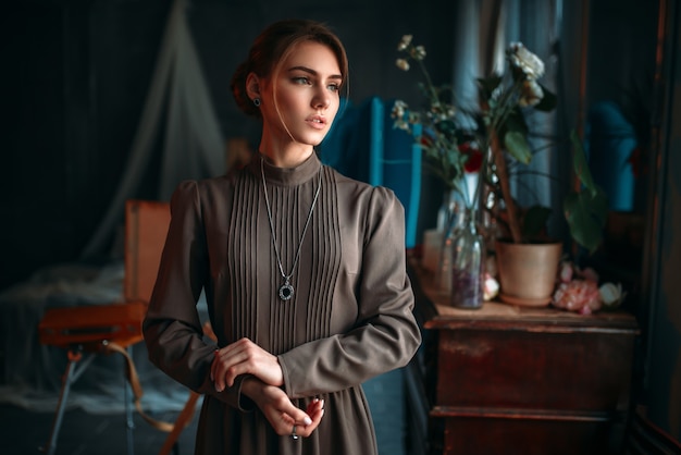 Beautiful female poseur in dress in art studio.