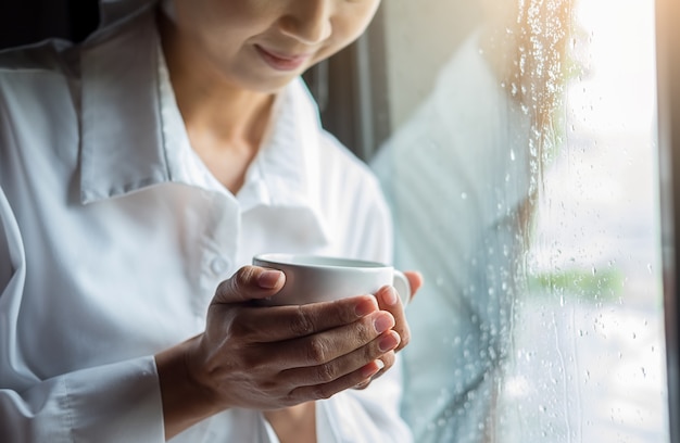 美しい女性がベッドに座って、彼女の手で本を読む。