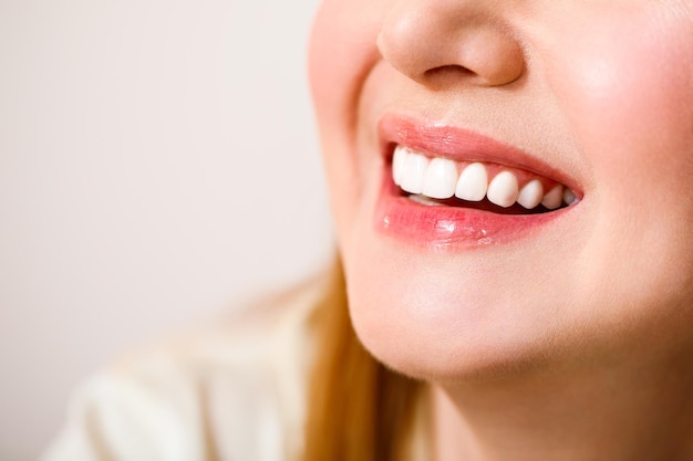 Beautiful female smile after teeth whitening procedure Dental care Dentistry concept On a blue background