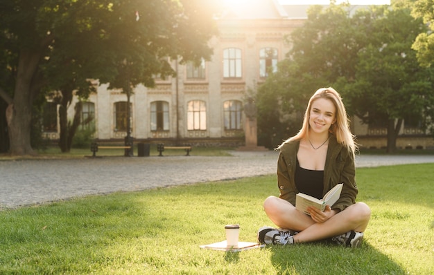 Foto bella studentessa con un ampio sorriso che tiene i taccuini