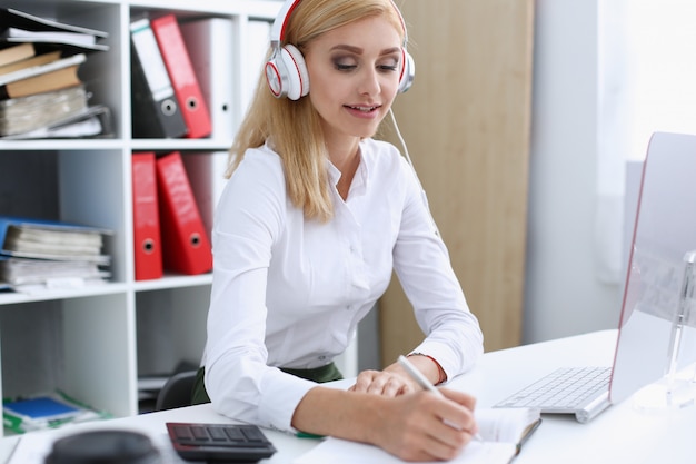 Beautiful female student with headphones listening to music