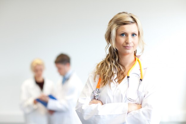 Beautiful female surgeon with her team behind her