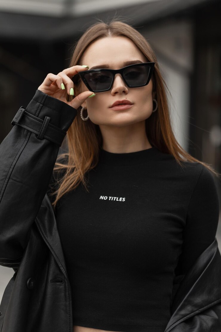 Photo beautiful female urban portrait of a beautiful young girl model in fashionable black clothes wears black cool fashion sunglasses on the street